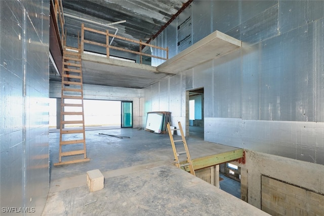 938 San Carlos Dr, Fort Myers Beach, FL 33931 - miscellaneous room featuring unfinished concrete floors and a towering ceiling