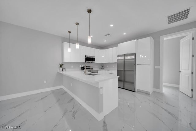 3103 Karen Ave S, Lehigh Acres, FL 33976 - kitchen with appliances with stainless steel finishes, a peninsula, light marble finish floors, light countertops, and white cabinetry