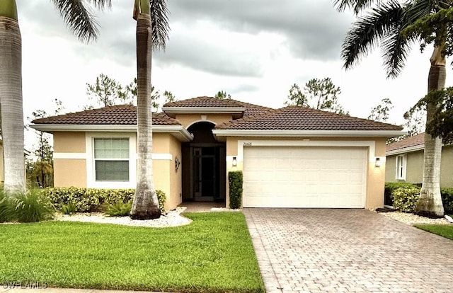 20608 Long Pond Rd, North Fort Myers, FL 33917 - view of front of home featuring decorative driveway, a garage, stucco siding, a front lawn, and a tile roof