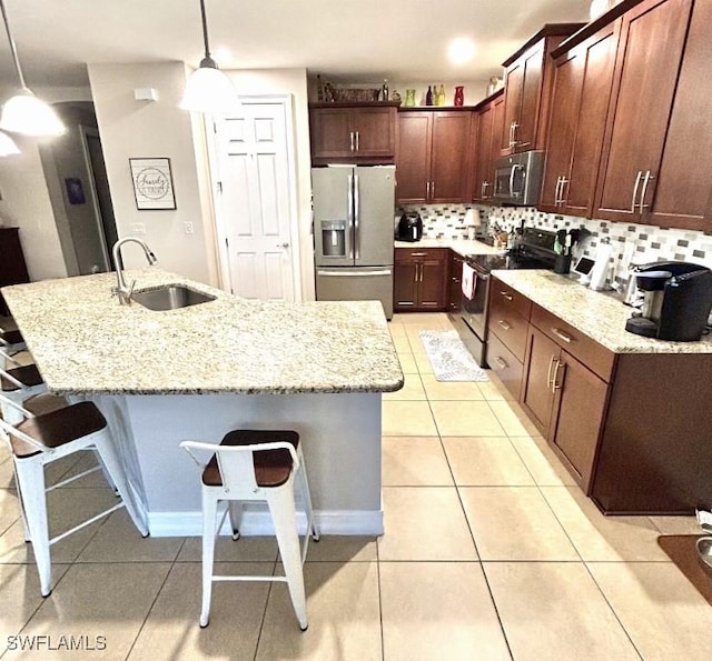20608 Long Pond Rd, North Fort Myers, FL 33917 - kitchen with appliances with stainless steel finishes, a breakfast bar, backsplash, light tile patterned flooring, and light stone counters