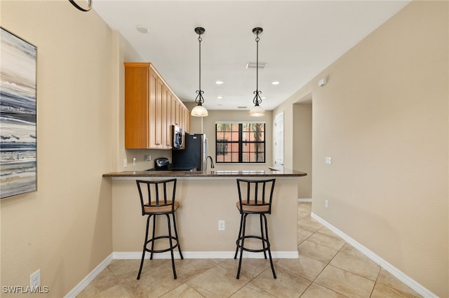 11999 Palba Way Unit 6405, Fort Myers, FL 33912 - kitchen with stainless steel microwave, freestanding refrigerator, a kitchen breakfast bar, a peninsula, and decorative light fixtures