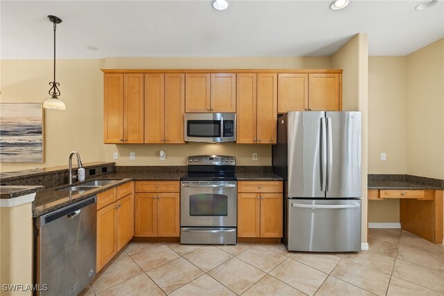 11999 Palba Way Unit 6405, Fort Myers, FL 33912 - kitchen with appliances with stainless steel finishes, a peninsula, dark stone counters, hanging light fixtures, and light tile patterned floors