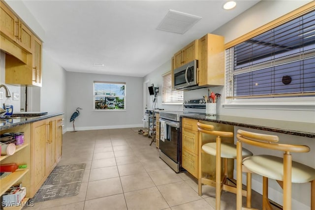 5251-5253 Serenity Cv, Bokeelia, FL 33922 - kitchen with stainless steel appliances, light tile patterned floors, and dark stone countertops