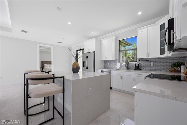 4325 47th Ave NE, Naples, FL 34120 - kitchen with stainless steel appliances, tasteful backsplash, ornamental molding, light stone counters, and white cabinetry