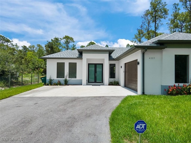 4325 47th Ave NE, Naples, FL 34120 - view of front of property with french doors, stucco siding, a garage, driveway, and a shingled roof