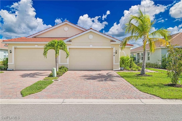 4209 Bloomfield St, Fort Myers, FL 33916 - mediterranean / spanish house featuring decorative driveway, stucco siding, and an attached garage