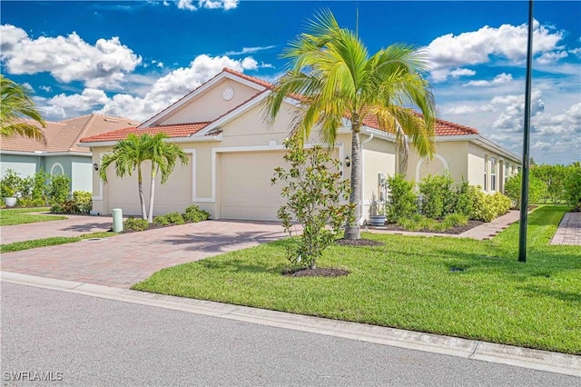 4209 Bloomfield St, Fort Myers, FL 33916 - mediterranean / spanish-style home with driveway, a garage, stucco siding, a front yard, and a tile roof