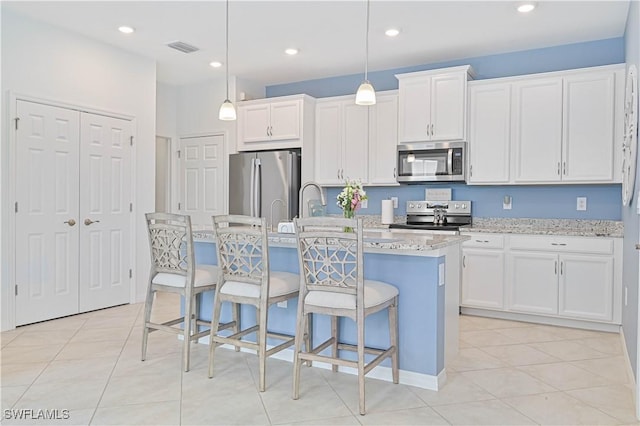4209 Bloomfield St, Fort Myers, FL 33916 - kitchen with appliances with stainless steel finishes, a center island with sink, a kitchen breakfast bar, white cabinets, and light tile patterned floors
