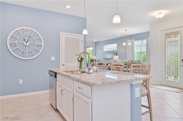 4209 Bloomfield St, Fort Myers, FL 33916 - kitchen featuring light tile patterned floors, white cabinets, decorative light fixtures, light stone countertops, and stainless steel dishwasher