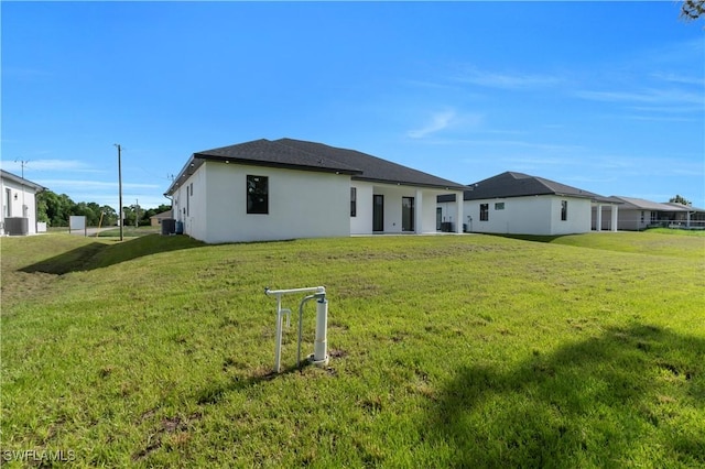 3513 36th St SW, Lehigh Acres, FL 33976 - rear view of house with stucco siding and a lawn