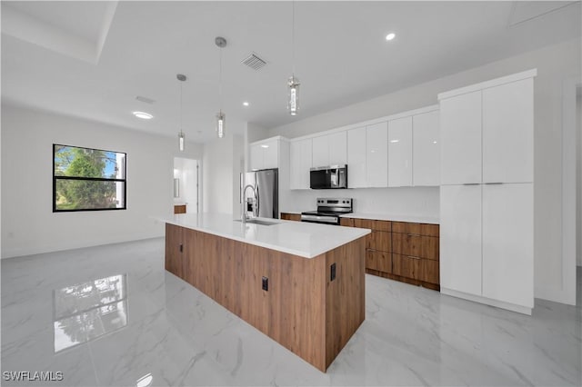 3513 36th St SW, Lehigh Acres, FL 33976 - kitchen featuring appliances with stainless steel finishes, modern cabinets, white cabinets, an island with sink, and light marble finish flooring