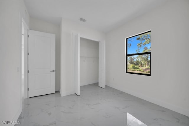 3513 36th St SW, Lehigh Acres, FL 33976 - unfurnished bedroom with light marble finish floors and a closet
