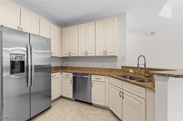 16142 Via Solera Cir Unit 103, Fort Myers, FL 33908 - kitchen featuring stainless steel appliances, dark stone countertops, a peninsula, and light tile patterned floors
