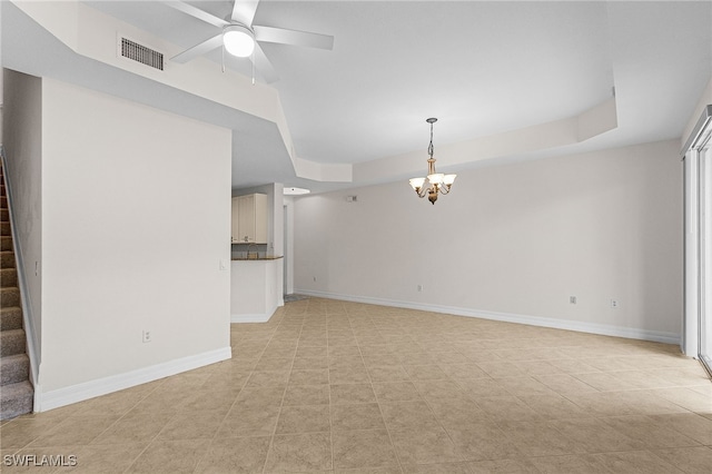16142 Via Solera Cir Unit 103, Fort Myers, FL 33908 - unfurnished living room featuring a chandelier, stairs, a tray ceiling, and ceiling fan