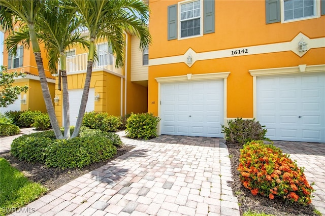 16142 Via Solera Cir Unit 103, Fort Myers, FL 33908 - view of front of property with stucco siding, an attached garage, and decorative driveway