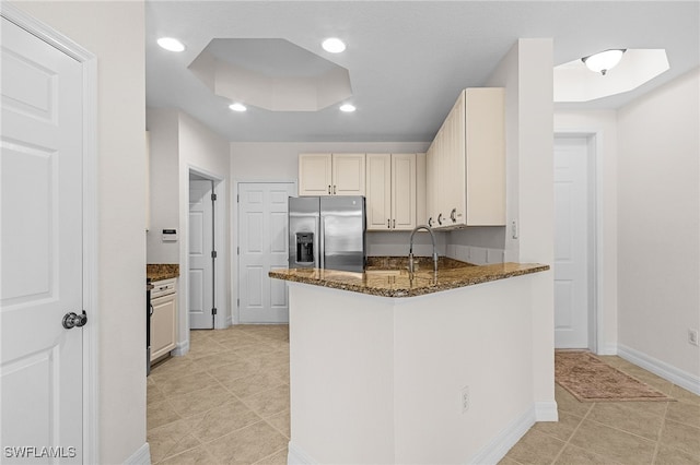16142 Via Solera Cir Unit 103, Fort Myers, FL 33908 - kitchen featuring stainless steel refrigerator with ice dispenser, dark stone counters, light tile patterned floors, a peninsula, and recessed lighting