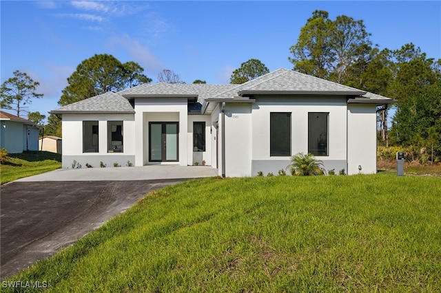 3587 18th Ave SE, Naples, FL 34117 - prairie-style home with a shingled roof, a front lawn, and stucco siding