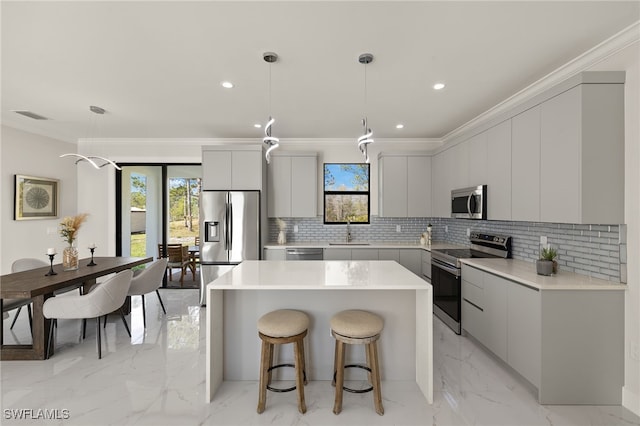 3587 18th Ave SE, Naples, FL 34117 - kitchen featuring stainless steel appliances, modern cabinets, a center island, a breakfast bar area, and ornamental molding