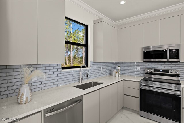 3587 18th Ave SE, Naples, FL 34117 - kitchen featuring appliances with stainless steel finishes, modern cabinets, crown molding, light marble finish flooring, and backsplash