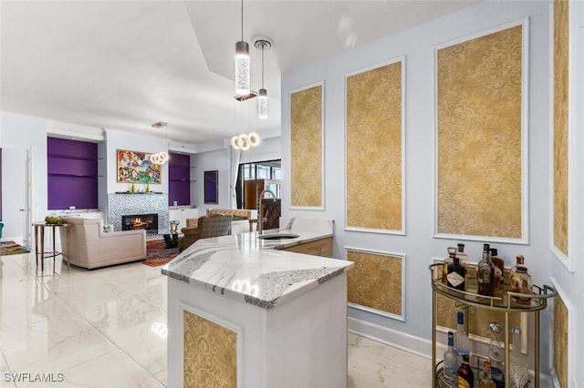 11640 Court Of Palms Unit 602, Fort Myers, FL 33908 - kitchen with light marble finish floors, a warm lit fireplace, light stone countertops, a peninsula, and decorative light fixtures