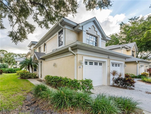 2852 Aintree Ln Unit K201, Naples, FL 34112 - view of side of property with stucco siding, an attached garage, concrete driveway, and a lawn