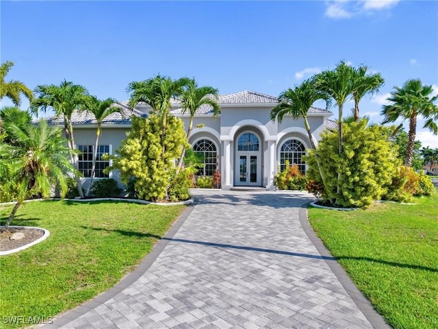 2705 SW 30th Ter, Cape Coral, FL 33914 - mediterranean / spanish-style home with french doors, stucco siding, a front lawn, and driveway