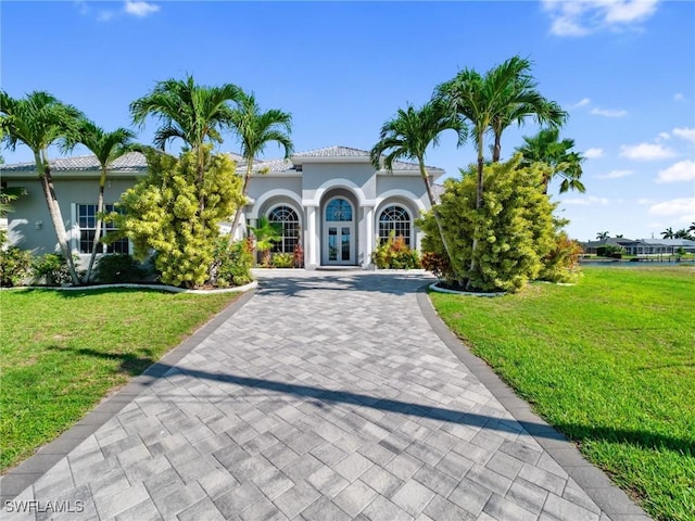 2705 SW 30th Ter, Cape Coral, FL 33914 - mediterranean / spanish home featuring french doors, stucco siding, a front yard, and decorative driveway
