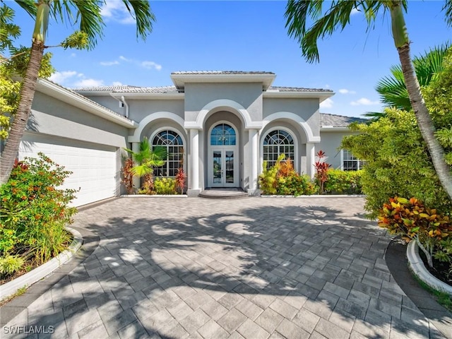 2705 SW 30th Ter, Cape Coral, FL 33914 - mediterranean / spanish house featuring french doors, stucco siding, a garage, and decorative driveway