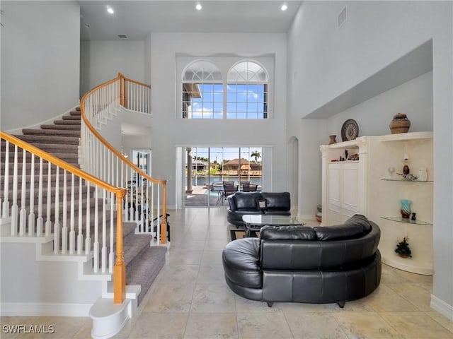2705 SW 30th Ter, Cape Coral, FL 33914 - living room with stairs, a high ceiling, recessed lighting, and tile patterned floors