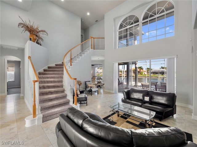 2705 SW 30th Ter, Cape Coral, FL 33914 - living room featuring stairway, a high ceiling, arched walkways, recessed lighting, and a water view