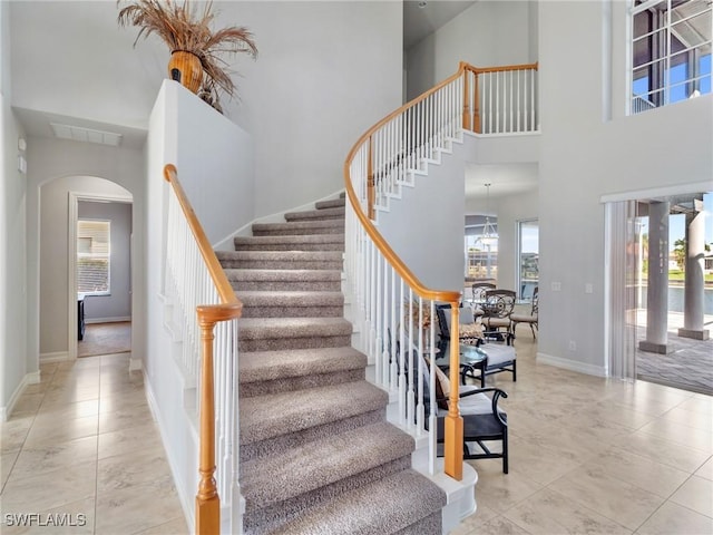 2705 SW 30th Ter, Cape Coral, FL 33914 - stairway featuring arched walkways, a towering ceiling, and tile patterned flooring