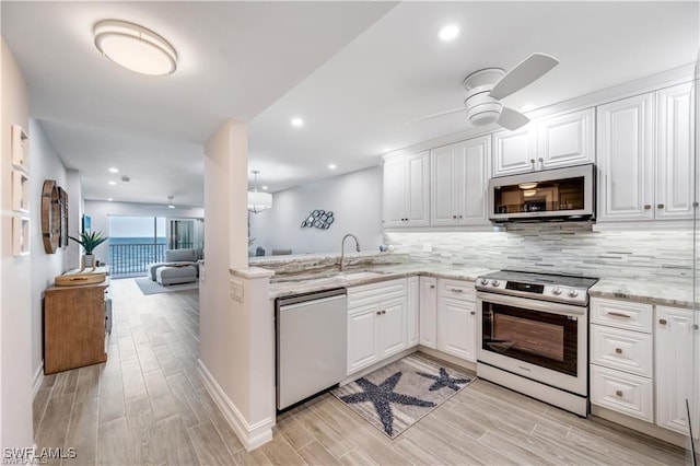 26000 Hickory Blvd Unit 205, Bonita Springs, FL 34134 - kitchen with appliances with stainless steel finishes, ceiling fan, light wood-style floors, backsplash, and recessed lighting