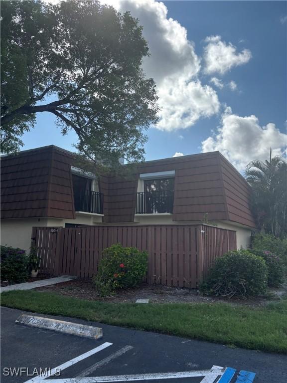 5245 Cedarbend Dr Unit 4, Fort Myers, FL 33919 - view of side of home featuring uncovered parking and mansard roof