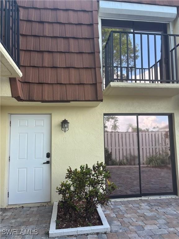 5245 Cedarbend Dr Unit 4, Fort Myers, FL 33919 - view of exterior entry with stucco siding and mansard roof