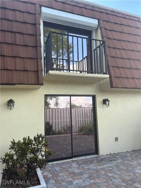 5245 Cedarbend Dr Unit 4, Fort Myers, FL 33919 - entrance to property with stucco siding, a balcony, and mansard roof