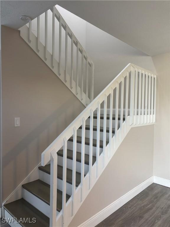 5245 Cedarbend Dr Unit 4, Fort Myers, FL 33919 - stairway featuring baseboards and wood finished floors