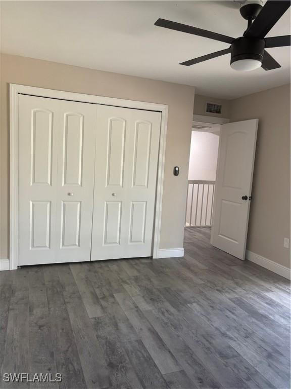 5245 Cedarbend Dr Unit 4, Fort Myers, FL 33919 - unfurnished bedroom with a closet, dark wood-style floors, and a ceiling fan