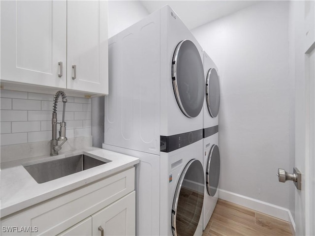 505 Monterey Ave, Cape Coral, FL 33904 - laundry area featuring stacked washer / drying machine, cabinet space, and light wood-style flooring