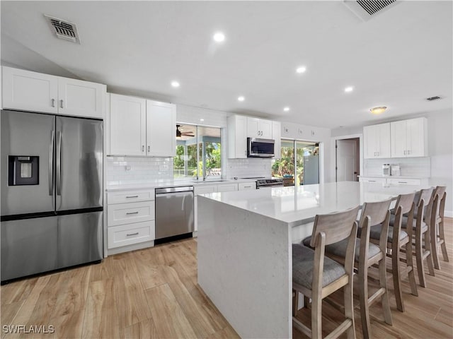 505 Monterey Ave, Cape Coral, FL 33904 - kitchen with stainless steel appliances, light wood-style floors, tasteful backsplash, white cabinetry, and recessed lighting