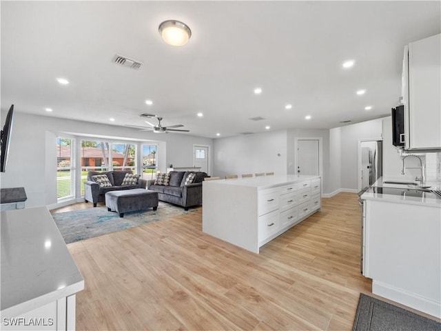 505 Monterey Ave, Cape Coral, FL 33904 - kitchen with a center island, light wood-style flooring, white cabinetry, stainless steel appliances, and recessed lighting