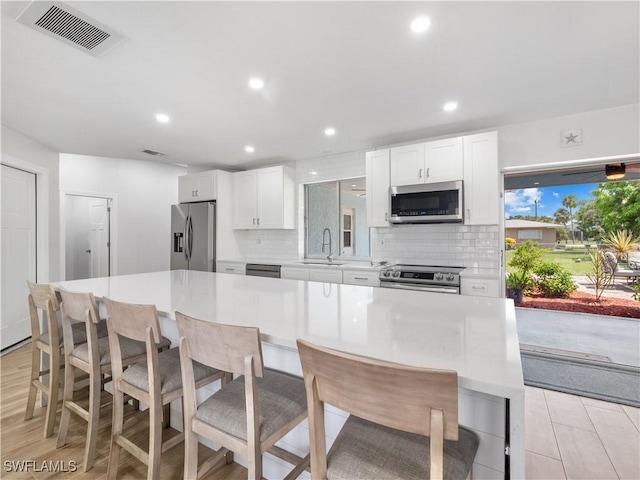 505 Monterey Ave, Cape Coral, FL 33904 - kitchen with appliances with stainless steel finishes, backsplash, white cabinetry, light countertops, and recessed lighting