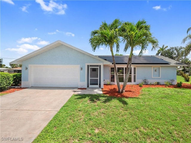 505 Monterey Ave, Cape Coral, FL 33904 - ranch-style home featuring a garage, roof mounted solar panels, a front yard, stucco siding, and driveway