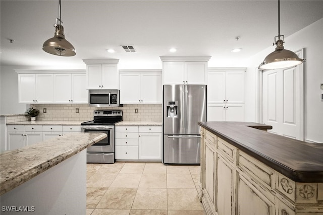 8701 Piazza Del Lago Cir Unit 101, Estero, FL 33928 - kitchen featuring stainless steel appliances, backsplash, decorative light fixtures, white cabinets, and recessed lighting