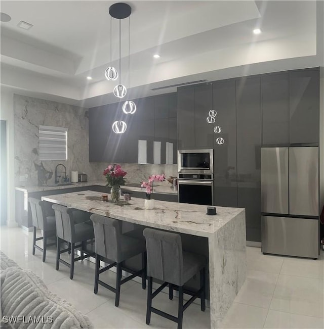 4067 33rd Ave NE, Naples, FL 34120 - kitchen featuring appliances with stainless steel finishes, modern cabinets, light tile patterned floors, a center island, and recessed lighting