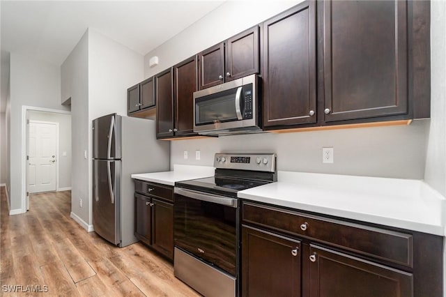 159 Kirby St, Port Charlotte, FL 33954 - kitchen with appliances with stainless steel finishes, light countertops, light wood-style flooring, and dark brown cabinets