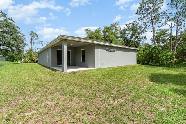 159 Kirby St, Port Charlotte, FL 33954 - back of house with stucco siding, a patio, and a lawn
