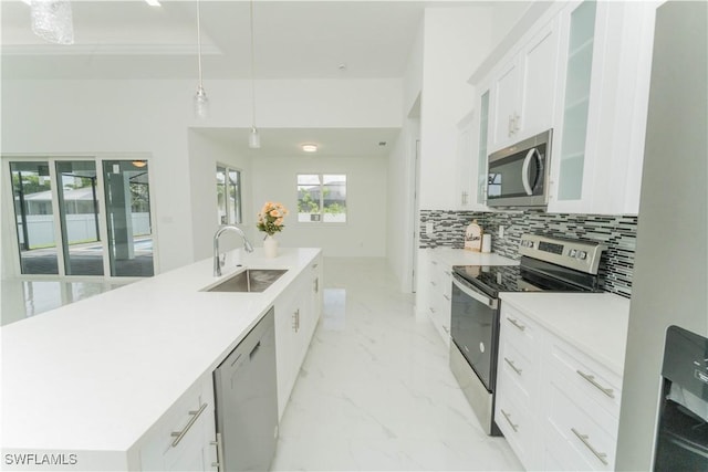 3923 NW 38th St, Cape Coral, FL 33993 - kitchen with appliances with stainless steel finishes, a spacious island, glass insert cabinets, white cabinets, and backsplash