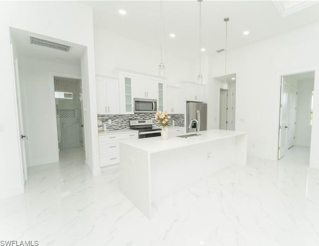 3923 NW 38th St, Cape Coral, FL 33993 - kitchen with stainless steel appliances, light marble finish flooring, white cabinetry, recessed lighting, and a large island