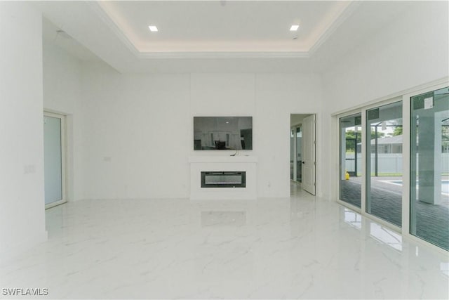 3923 NW 38th St, Cape Coral, FL 33993 - unfurnished living room with a tray ceiling, a high ceiling, a glass covered fireplace, and marble finish floors