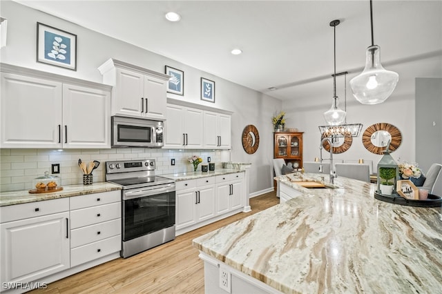8608 Via Rapallo Dr Unit 206, Estero, FL 33928 - kitchen featuring appliances with stainless steel finishes, decorative backsplash, white cabinetry, light wood-type flooring, and recessed lighting